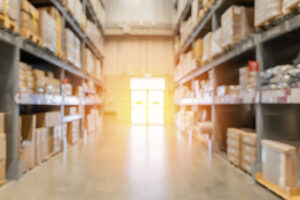 Blur large warehouse products goods stock factory inventory storage area for background